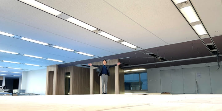 木目調の壁に変化したオフィスの広さを表現する人事部の大湯